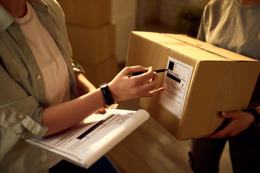 Unrecognizable couriers preparing packages for a delivery in the office.